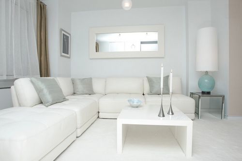 Desain ruang tamu dengan sofa putih yang elegan